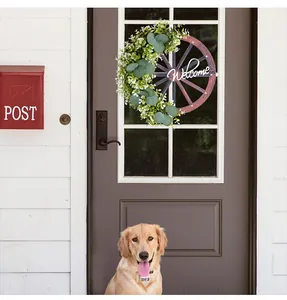 Couronne printanière décorative avec panneau Welcome sur une porte de maison sombre.