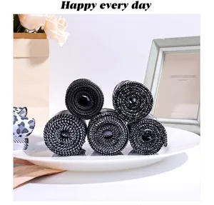 Close-up view of five rolled black and white striped decorative ribbons on a plate