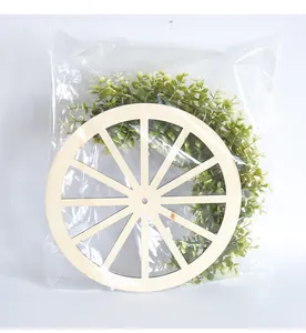 Couronne de roue de charrette en bois avec feuilles vertes dans un sac plastique