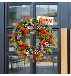 Vibrant eucalyptus wreath featuring artificial fruits and berries displayed on a glass door