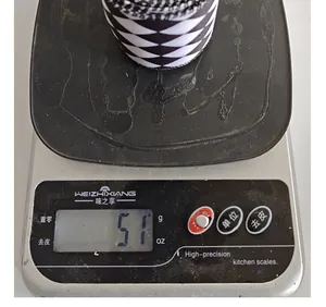 Detail view of a roll of black and white diamond ribbon weighing 51g on a scale