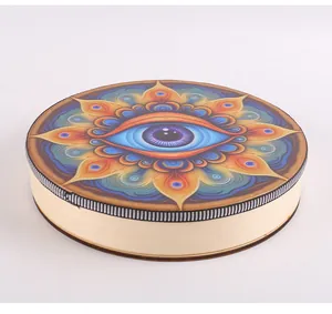 Detail view of a handmade Shaman drum featuring a vibrant evil eye mandala design.