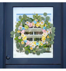 Couronne de fleurs printanière avec marguerites et eucalyptus sur une porte bleue foncée