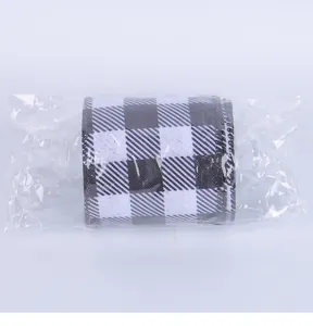Close-up of black and white buffalo check ribbon in plastic packaging for DIY crafts.