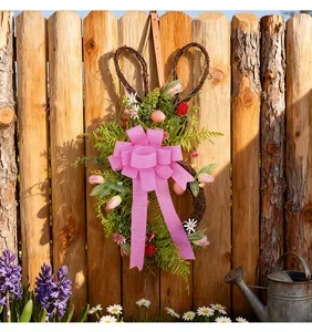 Dettaglio della ghirlanda di coniglio pasquale con fiocco rosa su staccionata legno.