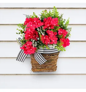 Cesto appeso con fiori artificiali rossi e un fiocco a strisce bianche e nere.