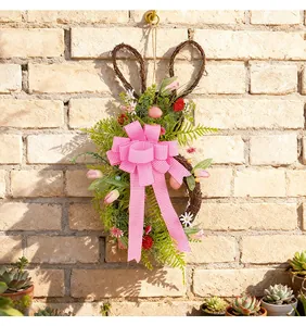 Dettaglio ghirlanda coniglio di Pasqua con fiocco rosa su sfondo di muro di mattoni