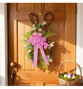 Ghirlanda di Pasqua a forma di coniglio con fiocco rosa appesa a una porta di legno