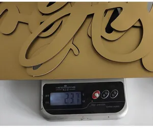 Primer plano que muestra el peso del cartel decorativo de madera dorada Oh Baby de 237g