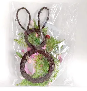 Dettaglio ghirlanda pasquale a forma di coniglio con fiocco rosa in busta trasparente