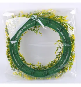 Back view of artificial spring eucalyptus wreath in transparent plastic packaging