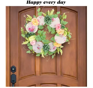 Ghirlanda di fiori primaverili con rose rosa e piatti in porcellana su porta in legno.