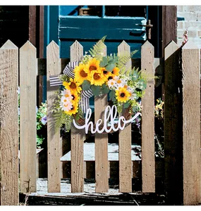 Sunflower wreath with hello sign and daisy flowers hanging on a rustic wooden fence