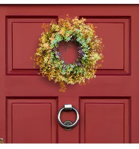 Vibrant artificial wildflower wreath hanging on a classic red door for home decor.
