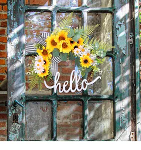 Rustic farmhouse sunflower wreath with hello sign hanging on a vintage wooden door