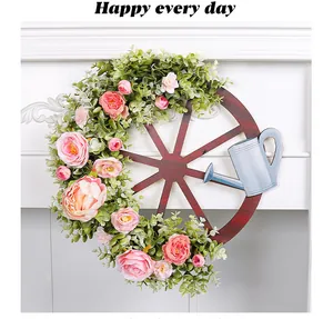 Bloemen lentekrans met vintage wiel en blauwe gieter voor wanddecoratie in huis
