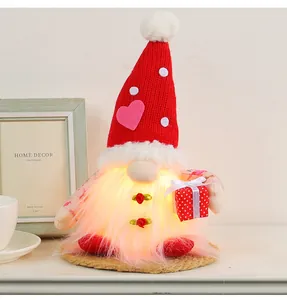 Nahaufnahme eines leuchtenden Valentinstags-Gnomes mit rotem Herz-Hut und Geschenkbox