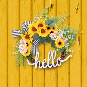 Decorative rustic sunflower and daisy wreath with hello wooden sign on yellow wood