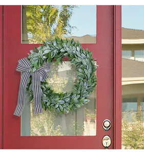 Artificial lamb's ear wreath with a classic black and white striped bow on a door.