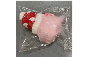 Detaillierte Ansicht des Valentinstag-Gnom-Plüschs in transparenter Verpackung auf grauem Boden