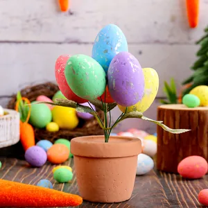 Festliche Osterdekoration Topfpflanze mit gesprenkelten bunten Eiern für den Tisch