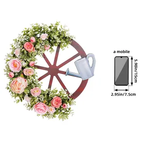 Rustieke houten wielkrans met roze rozen en blauwe gieter voor lentedecoratie
