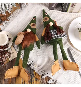 Detailansicht von Kaffee-Wichteln mit langen Beinen und grünen Hüten auf Holztisch