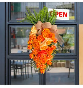 Decoratieve paasbloemkrans in de vorm van een wortel hangend aan een glazen deur decor