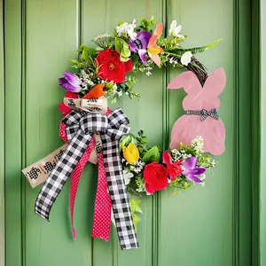 Bunter Osterkranz mit rosa Hasen-Holzschild und Blumen an einer grünen Haustür