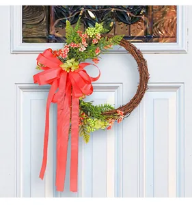 Decorative twig wreath with large coral bow hanging on a white door for patio decor