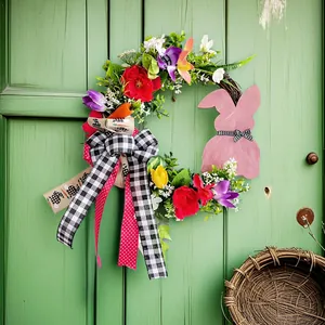 Handgefertigter Osterkranz mit rosa Holzhase und bunten Kunstblumen für die Türdeko