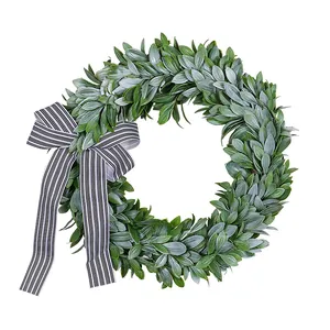 Handcrafted artificial green leaf wreath featuring a classic black and white striped bow.