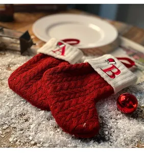 Close-up of red knitted Christmas stockings with white embroidered letter A and B