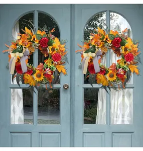 Decorative autumn harvest wreaths featuring maple leaves and sunflowers on blue doors