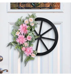 Rustic wagon wheel wreath with pink dahlias and greenery on a white front door