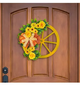 Frühlingshafter gelber Blumenkranz auf Holzrad mit orangefarbener Karoschleife an Tür