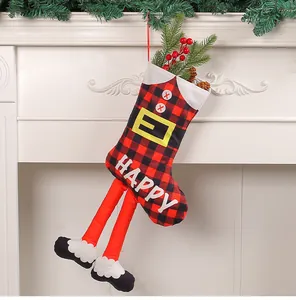 Calza di Natale creativa con gambe lunghe e motivo a quadri su camino bianco