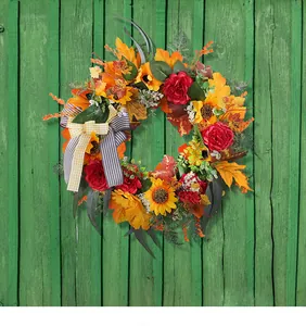 Detailed view of autumn wreath with maple leaves, sunflowers and a decorative bow.