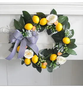 Close-up of artificial lemon wreath with white roses and a blue striped bow