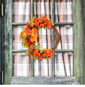 Corona de cosecha de otoño con calabazas colgada en ventana de madera rústica