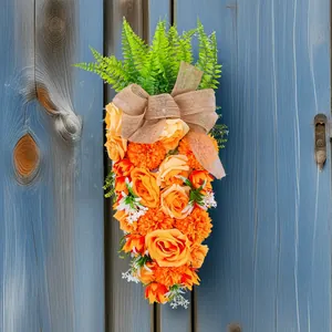 Pasen wortelvormige bloemenkrans met oranje rozen en jute strik op blauwe houten deur.