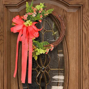 Natural twig wreath with vibrant red bow and delicate artificial flowers on a front door.