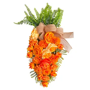 Kunstmatige paaswortel decoratie met oranje rozen en jute strik voor de deur