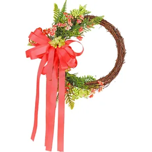 Decorative twig wreath with red floral accents and a large ribbon bow