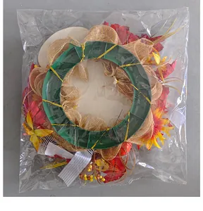 Back view of autumn harvest wreath with maple leaves and pumpkins in plastic packaging