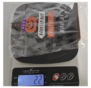Macro shot of a Halloween wooden sign ornament on a digital scale showing 22 grams.