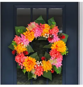 Close-up of vibrant autumn chrysanthemum wreath with pink and orange flowers on a door