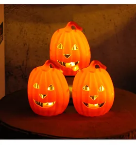 Warm glow from three stacked Halloween Jack-o'-lantern pumpkin lights on wood.