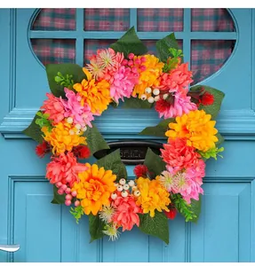 Macro view of a colorful autumn chrysanthemum wreath hanging on a rustic blue door.