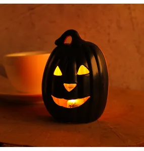 Close-up detail of a glowing black Halloween Jack-o'-lantern with a warm orange internal light